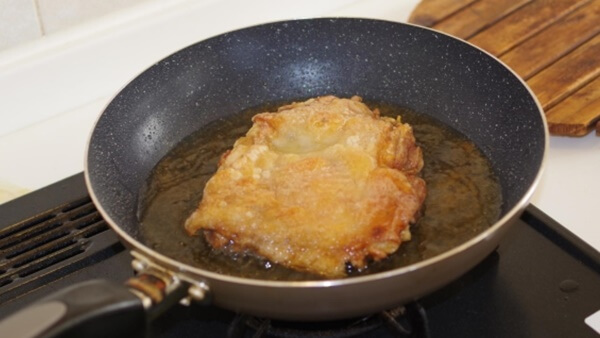 鶏肉を 揚げ焼きしている写真
